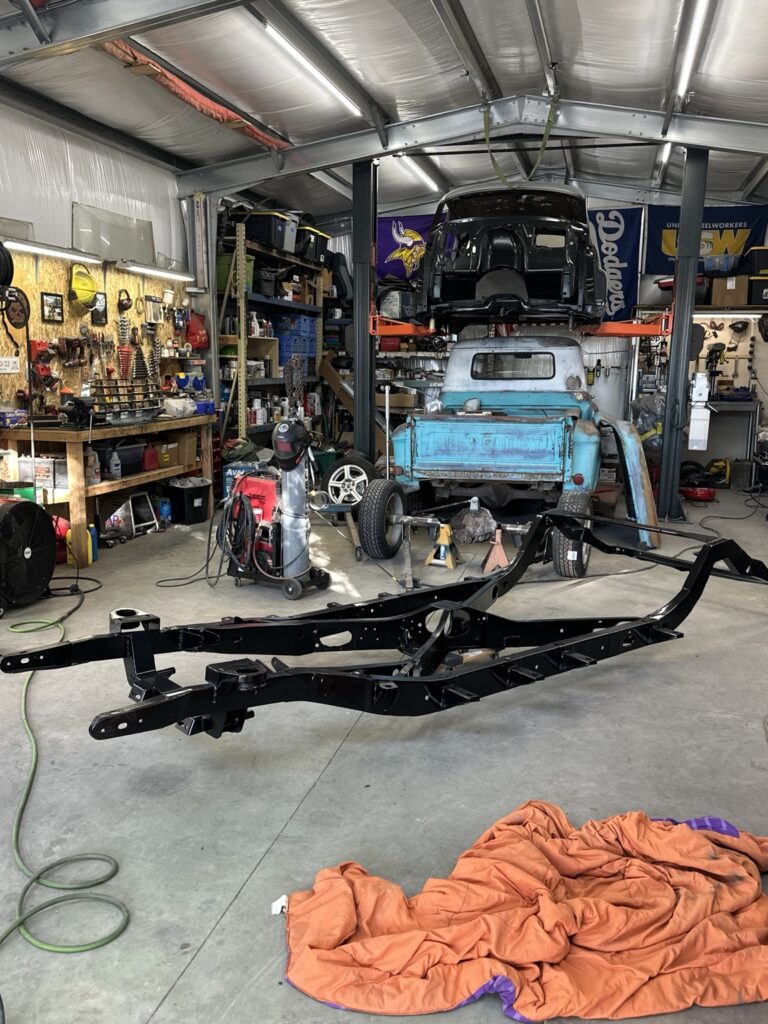 Ole Nasty bare black frame with the Buick body raised on the shop lift